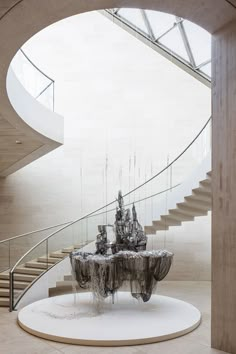 an artistic sculpture in the middle of a circular room with stairs and spiral staircases