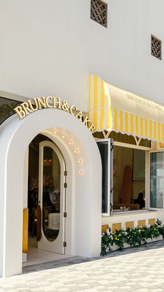 a white building with yellow and white awnings on it's front entrance