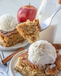 a piece of cake on a plate with ice cream and an apple in the background