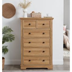 a wooden dresser sitting next to a plant in a room