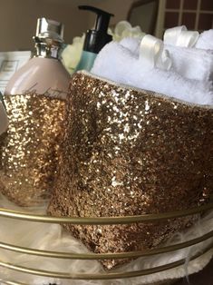 gold sequins and white towels are in a basket on a table with toiletries