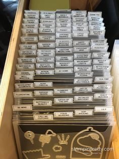 a stack of plastic business cards in a box on top of a wooden shelf next to a window