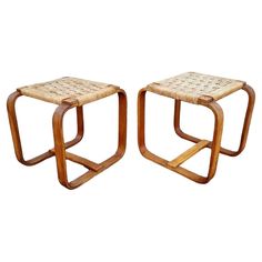 a pair of stools with woven seats