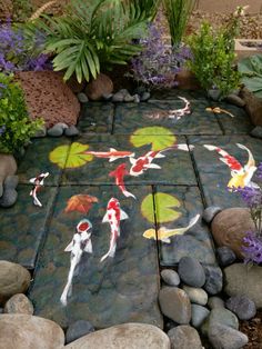 a garden with rocks and plants painted on the ground, along with koi fish