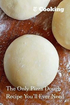 three uncooked pizza doughs sitting on top of a wooden table with flour sprinkled around them