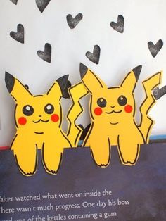 two yellow pikachu standing next to each other on top of a book page