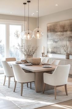 a dining room table with white chairs and a large painting on the wall behind it