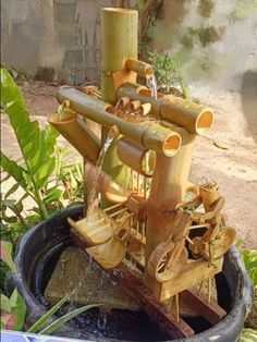 there is a water fountain made out of bamboo sticks and other things in the bucket