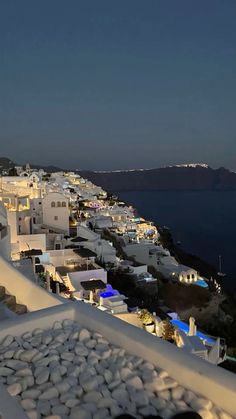 white buildings line the edge of a cliff at night