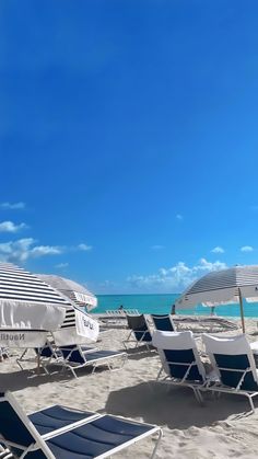 lounge chairs and umbrellas are on the beach