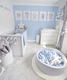 a baby's room is decorated in blue and white with lots of balls on the floor