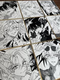 many anime characters are drawn in black and white paper on a table with pencils