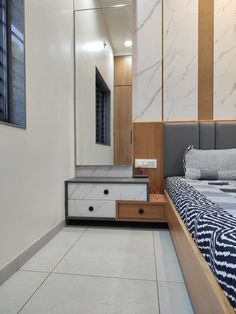 a bedroom with marbled flooring and white walls, along with a large mirror on the wall