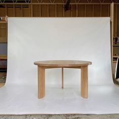 a wooden table sitting on top of a white sheet in front of a camera set up