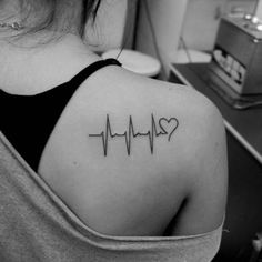 a woman with a heartbeat tattoo on her shoulder