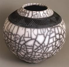 a black and white vase sitting on top of a table