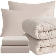 the comforter and sheets are folded neatly on top of each other, along with two pillows