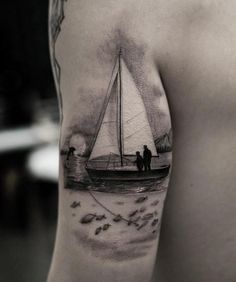 a man with a sailboat tattoo on his arm