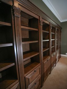 a large wooden bookcase in the corner of a room with carpeted flooring