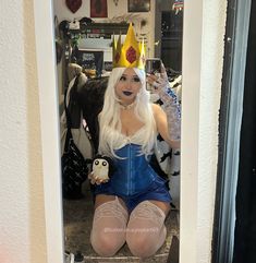 a woman in a blue cosplay sitting on the floor with her legs crossed