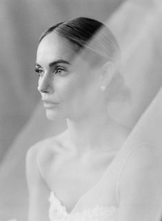 a black and white photo of a woman in a wedding dress looking off to the side