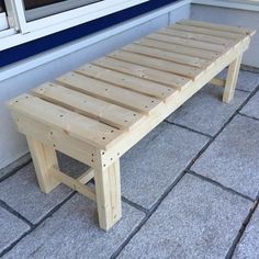 a wooden bench sitting on top of a tile floor next to a window sill