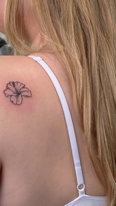 a woman with a flower tattoo on her shoulder