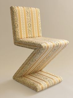 a chair that is sitting on top of a white surface with yellow and brown stripes