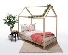 a bed with a wooden frame and pillows on top of it next to a potted plant