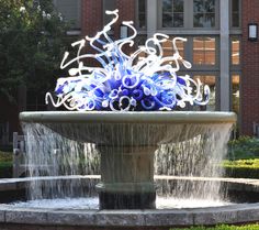 a fountain with blue and white lights in front of a building