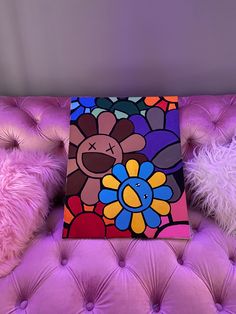 a brightly colored painting sitting on top of a purple couch