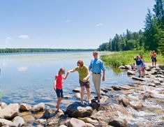 people are standing on rocks near the water