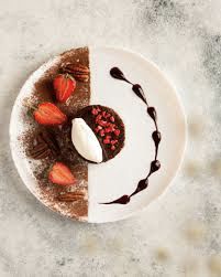 a white plate topped with chocolate cake and strawberries