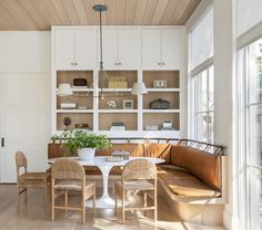 a dining room table and chairs with built in bookshelves