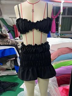 a mannequin wearing a black dress with red piping on the bust and bottom