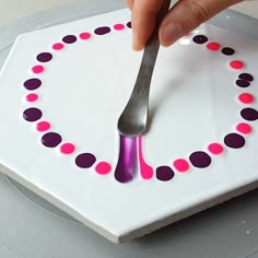 a person holding a fork over a plate with polka dot designs on it and the word love spelled in pink