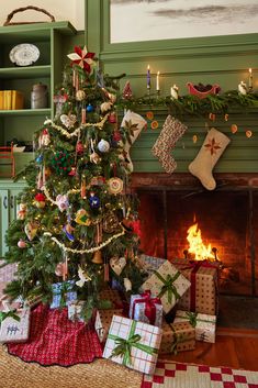 a decorated christmas tree in front of a fireplace