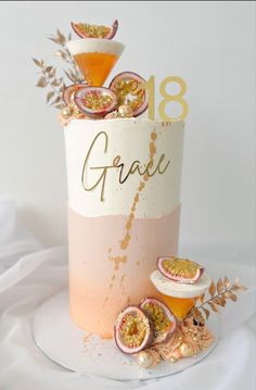 a cake that has some fruit on top of it with the word grace written in gold