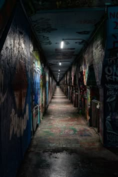 an empty hallway with graffiti all over the walls