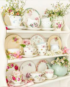 a china cabinet filled with lots of plates and flowers on top of each shelf,