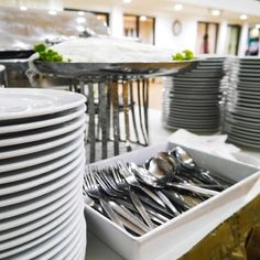 there are many plates and silverware in the trays on the table with each other