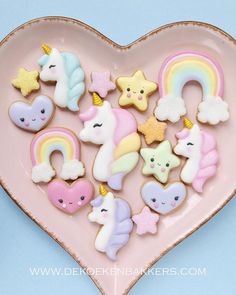 a pink heart shaped plate filled with lots of different types of unicorns and stars