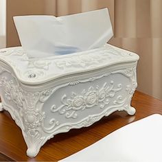 a tissue dispenser sitting on top of a wooden table