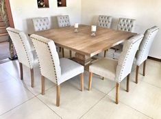 a wooden table with white chairs around it