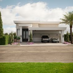 two cars are parked in front of a large white house with palm trees and bushes