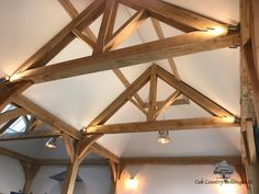 the inside of a building with wooden beams and lights