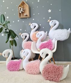 a group of flamingos sitting next to each other on a rug in front of a wall