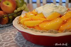 there is a pie with fruit in the bowl on the table next to grapes and oranges