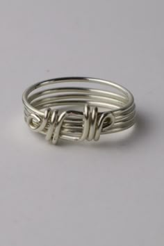 three silver rings with the word love written on each one, and two wire wrapped around them