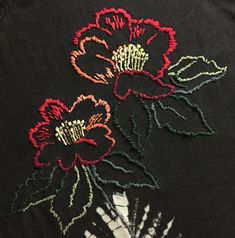 two embroidered flowers sitting on top of each other